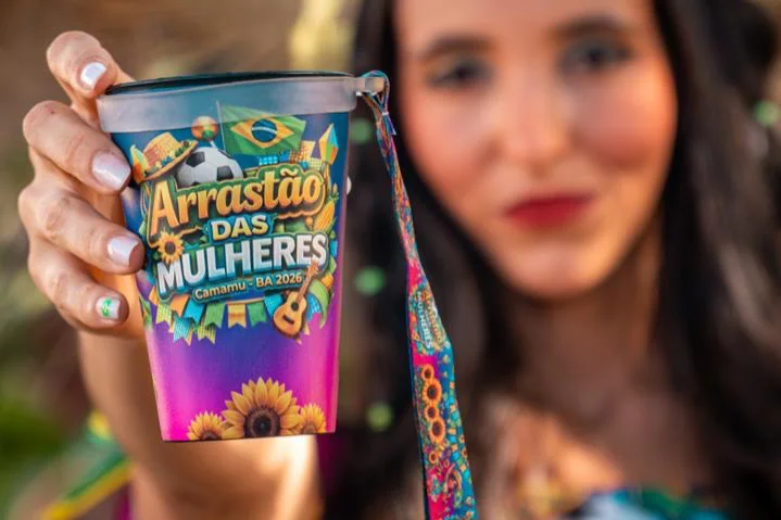 Copo com tirante personalizado do Arrastão das Mulheres, na mão de uma foliã, com o cordão impresso pendurado
